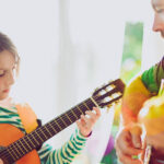 音乐治疗师与年轻女孩弹吉他音乐治疗