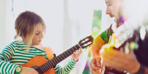 音乐治疗师在音乐疗法期间与年轻女孩一起弹吉他